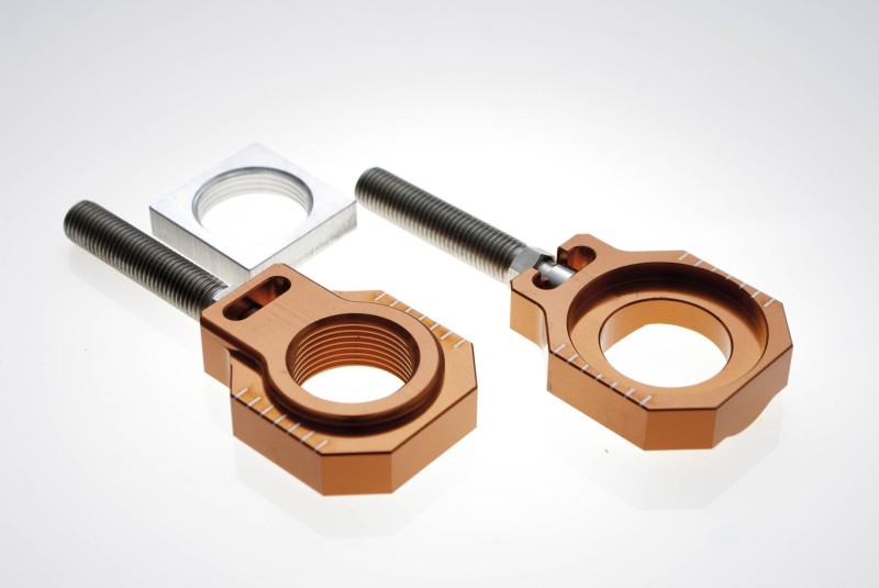 ACCEL NAPINACZ TYLNEJ OŚKI ZE ŚRUBĄ KTM SX/SXF 125-450 '13-19, HUSQVARNA TC 125/250 / FC 250/350/450 '15-18 (ŚR. 25MM) KOLOR POMARAŃCZOWY (KPL. 2SZT) (1)